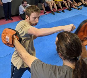 A picture of a student hitting pads to show the type of training someone signing up for Warriors Krav Maga Online Training would do